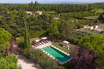 An aerial view of a large swimming pool surrounded by trees