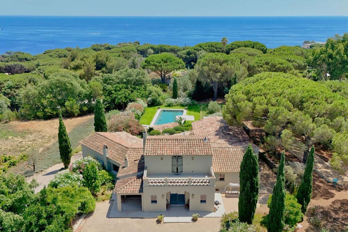 An aerial view of a house with a large pool