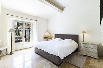 A bedroom with a large bed and a dresser that says luxury expertise