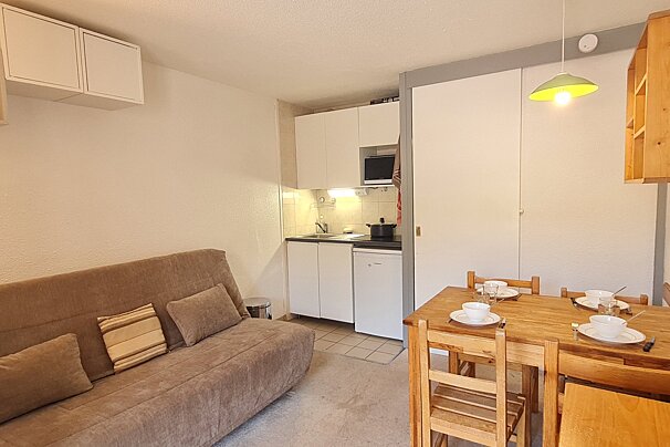 A living room with a couch and a table and chairs