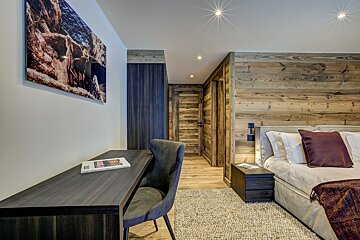 A bedroom with a wooden wall and a desk with a magazine on it