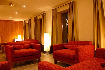 A living room with red chairs and a lamp