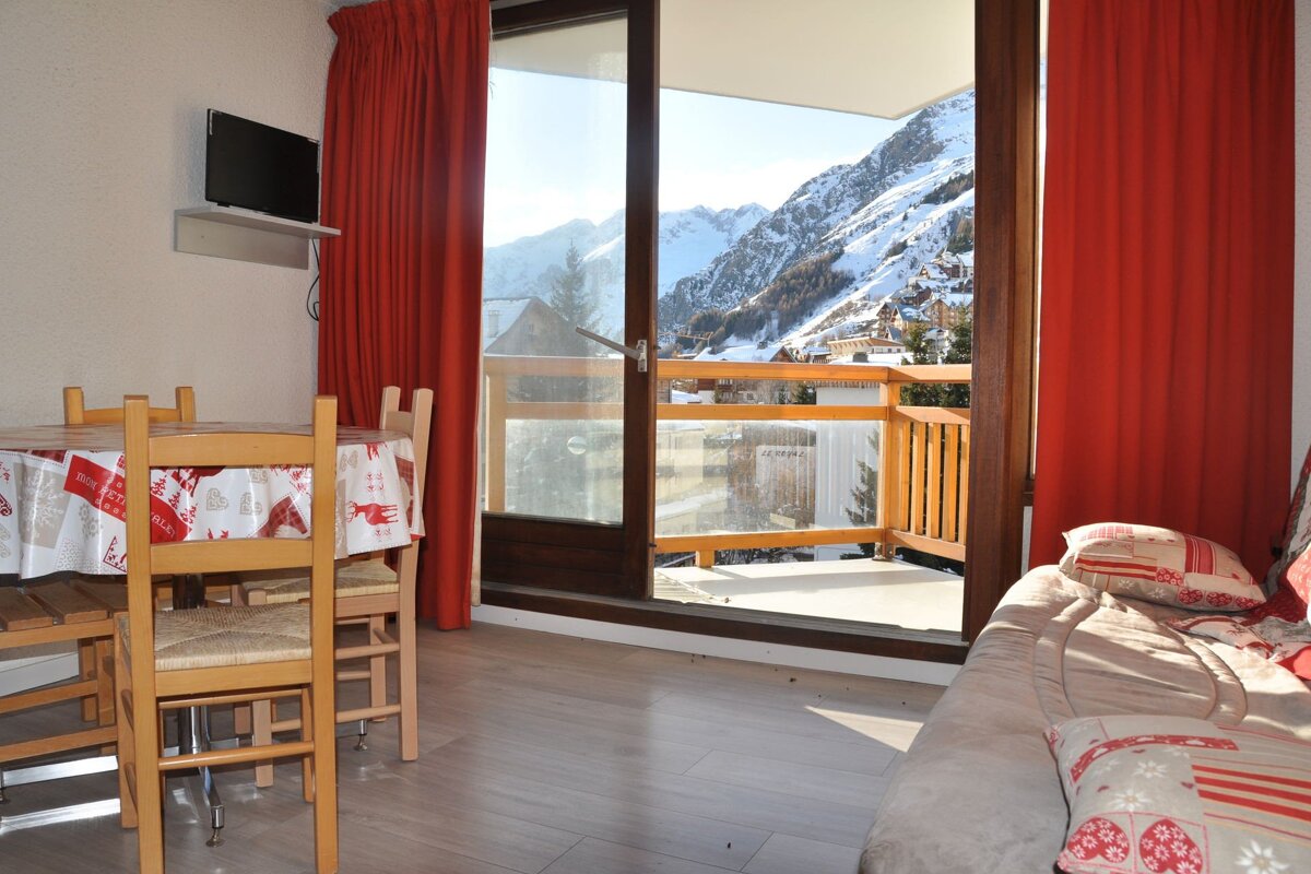 A living room with a table and chairs and a balcony