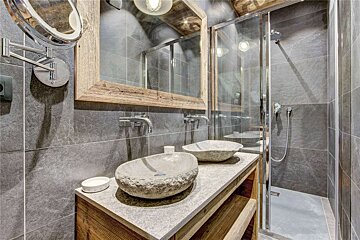 A bathroom with two sinks and a walk in shower
