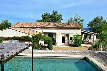 A house with a swimming pool in front of it