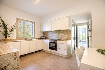 A kitchen with white cabinets and granite counter tops