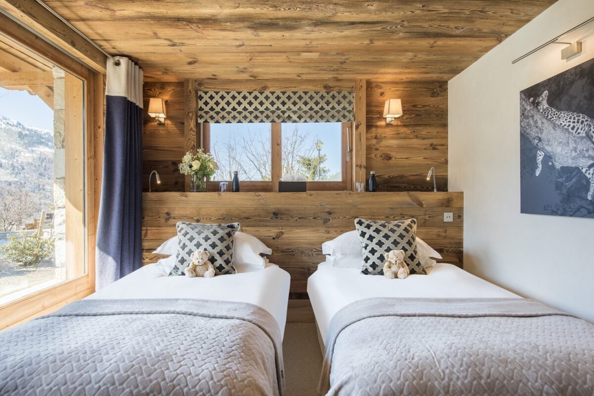 A bedroom with two beds and a picture of a leopard on the wall