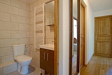 A bathroom with a toilet a sink and a mirror