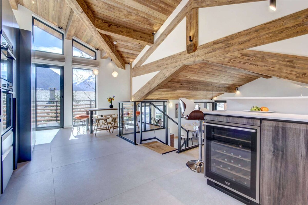 A kitchen with wooden beams and a wine cooler