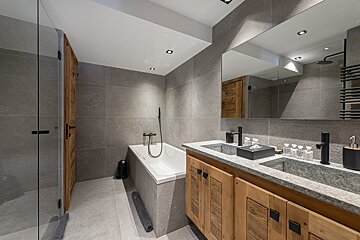 A bathroom with a bathtub and two sinks