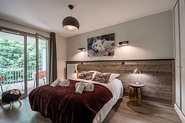 A bedroom with a bed and a picture of a wolf on the wall