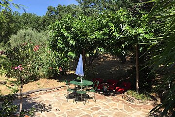 A patio with a table and chairs and a blue umbrella