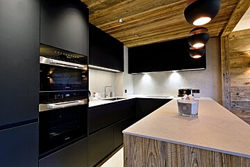 A kitchen with black cabinets and stainless steel appliances