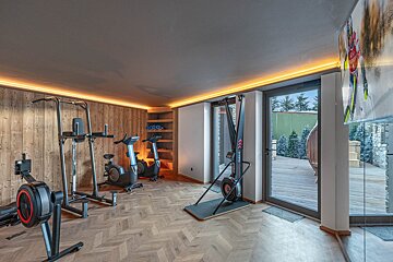 A gym with a rowing machine and a ski machine
