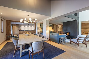 A dining room with a long wooden table and chairs