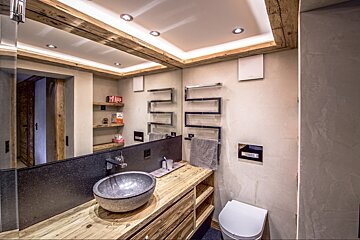 A bathroom with a toilet a sink and a mirror