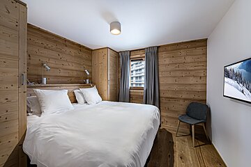 A bedroom with a large bed and a flat screen tv