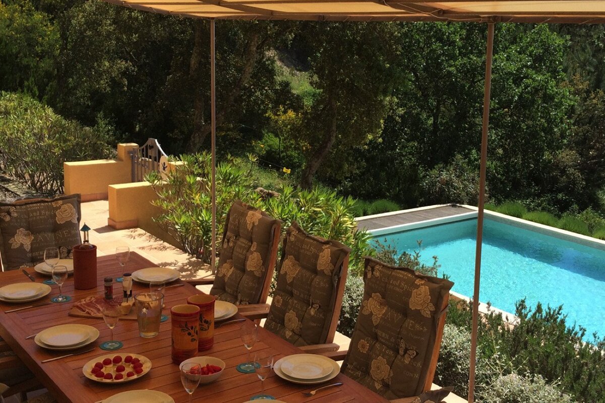 A table with plates and glasses and a wine bottle that says ' bordeaux ' on it