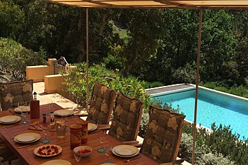 A table with plates and glasses and a wine bottle that says ' bordeaux ' on it