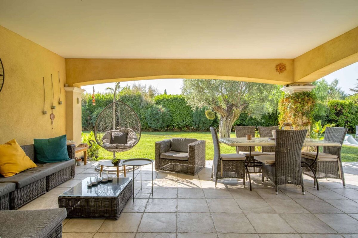 A patio with a table and chairs and a hanging chair