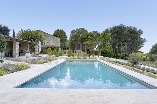 A large swimming pool with a house in the background