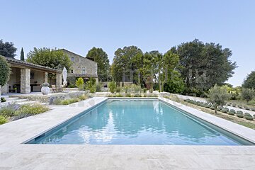 A large swimming pool with a house in the background