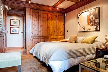 A bedroom with a bed and a painting on the wall