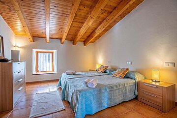 A bedroom with two beds and a wooden ceiling