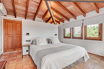 A bedroom with a canopy bed and a wooden ceiling