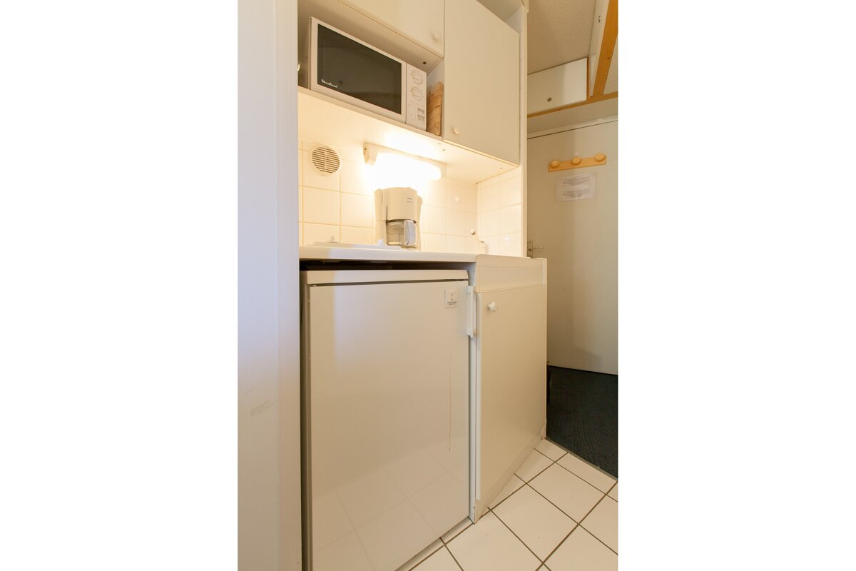 A small kitchen with a microwave and a coffee maker