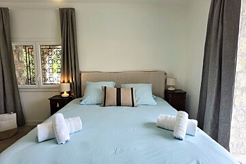 A bed with blue sheets and white towels on it