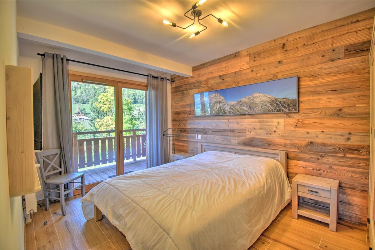 A bedroom with a bed and a picture of a mountain on the wall