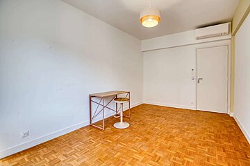 An empty room with a wooden floor and white walls