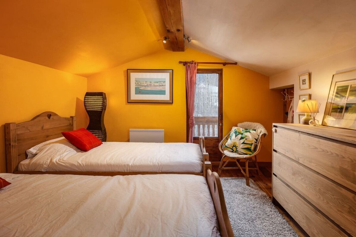 A bedroom with two twin beds and a dresser