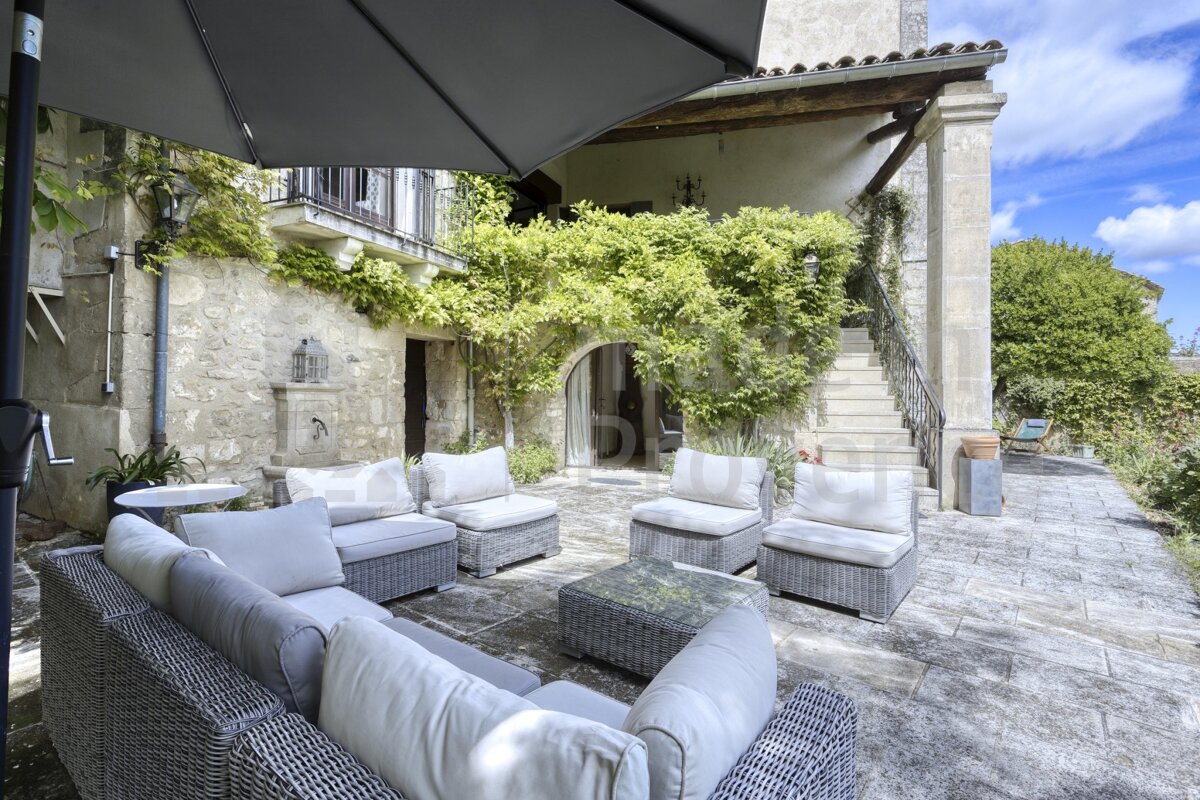 A patio with a couch and chairs under an umbrella that says ' immobilier ' on it
