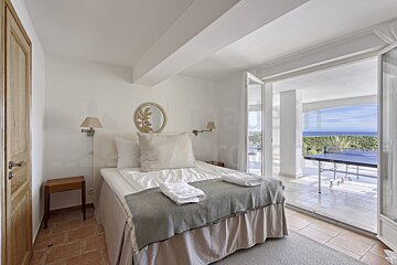 A bedroom with a bed and a view of the ocean