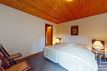 A bedroom with a bed and a poster on the wall that says haute savoie
