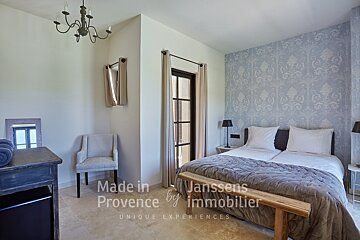 A bedroom with a bed made in provence by immobilier