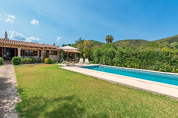 A house with a large swimming pool in front of it