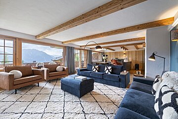 A living room with a blue couch and brown chairs