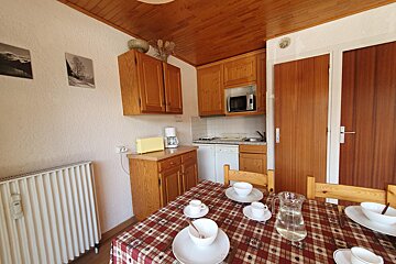 A kitchen with a table and chairs and a coffee maker