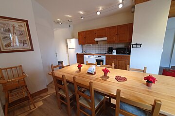 A kitchen with a table and chairs and a picture on the wall
