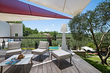 A deck with chairs and a table with a magazine on it