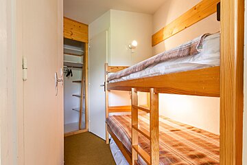 A bunk bed in a hallway next to a door