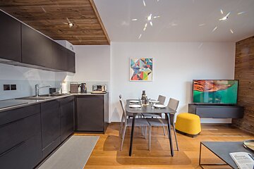 A kitchen with a table and chairs and a painting on the wall