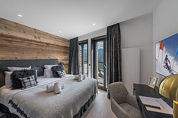 A bedroom with a painting of a skier on the wall