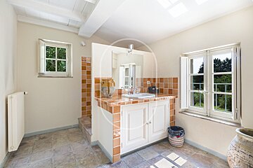 A bathroom with a sink and a window with shutters