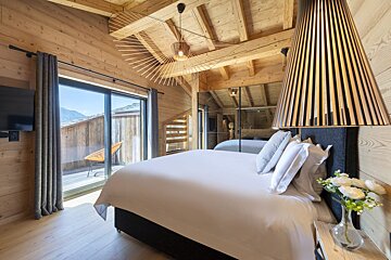 A bedroom with a large bed and sliding glass doors