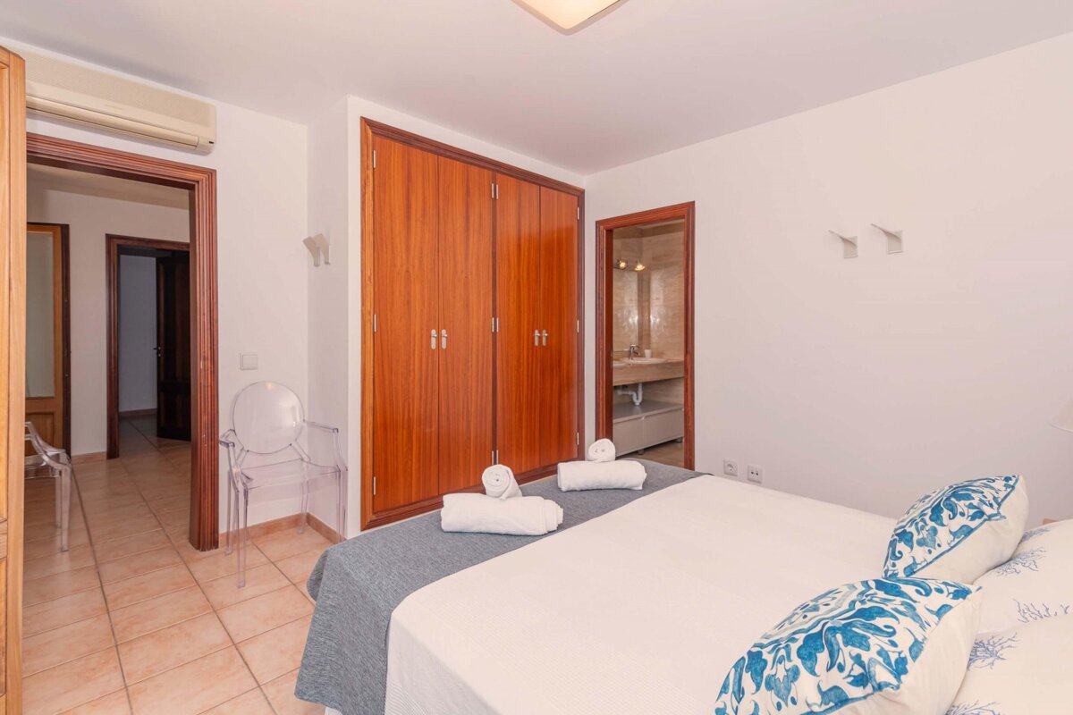 A bedroom with a king size bed and a chair