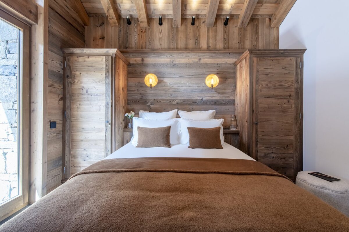 A bedroom with wooden walls and a bed